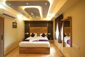 Un dormitorio con una cama grande en una habitación. en M M Hotel Royal Respite, en Coimbatore
