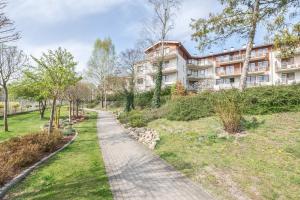 a path in front of a building at Neptun Park by NorthSide Apartments in Gdańsk