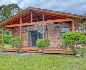 a stone house with a wrap around porch at lone pine estate in Delray Beach