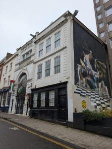 a white building with a mural on the side of it at Duel of Bristol House 6BR 12 beds in Bristol