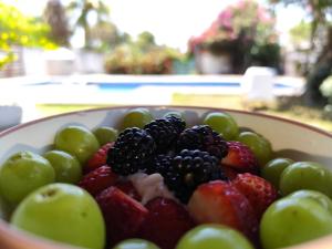 a bowl of strawberries and blackberries and green grapes at Villa kosniin in Tecolutla