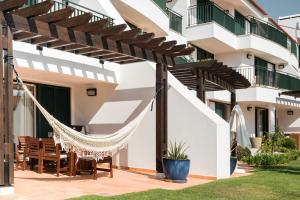 a hammock in the courtyard of a house at Birdsong Vila Sol Village by Experience MamiMi in Vilamoura