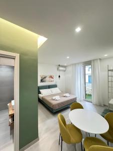 a bedroom with a bed and a table and chairs at I Faraglioni Comfort Rooms in Terrasini