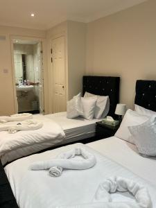 a hotel room with two beds with towels on them at 2 Bedroom Flat with 24 7 security and concierge in London +19 photos