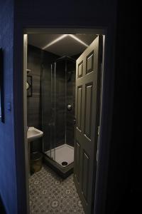 a bathroom with a shower and a toilet and a door at Ferny House in Blackpool