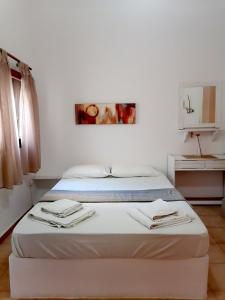 a bedroom with a bed with towels on it at Mar-Nik Village in Paliochori