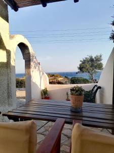 a wooden table on a patio with a view of the ocean at Mar-Nik Village in Paliochori