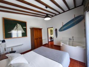 1 dormitorio con cama y bañera. en Posada Punta Liñera, en San Vicente de la Barquera