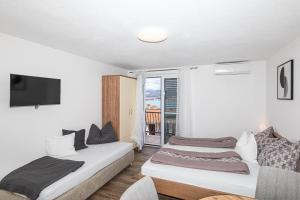 two beds in a room with a window at Apartman Simic in Trogir