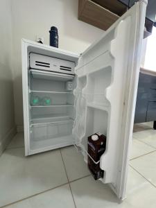 Un refrigerador vacío con la puerta abierta en una cocina. en Aconchego, en Santarém