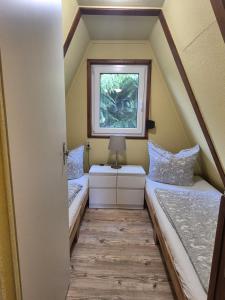 two beds in a tiny house with a window at Ferienhaus am Helenesee 1 in Frankfurt Oder