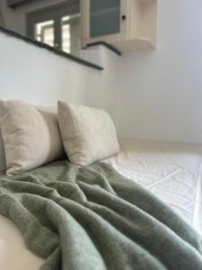 a bed with two pillows and a blanket on it at Lithari Traditional Apartment in Agios Sostis +30 photos