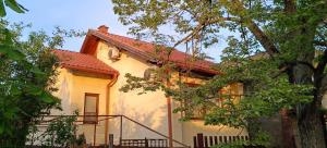 une maison blanche avec un toit rouge dans l'établissement Rigó Nyaralóház, à Lakitelek