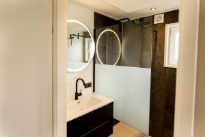 a bathroom with a sink and two mirrors at Hightree House - Luxe in de polder dichtbij Rotterdam en Zeeland in Oud-Beijerland +21 photos