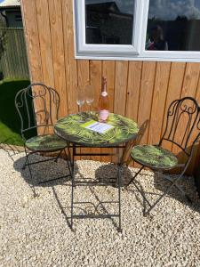 a table and two chairs with wine glasses on it at The Garden Room in Spittal