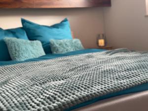 ein Schlafzimmer mit einem Bett mit blauen Kissen in der Unterkunft Haus Boddenruh Ferienwohnung Holz in Wiek auf Rügen 