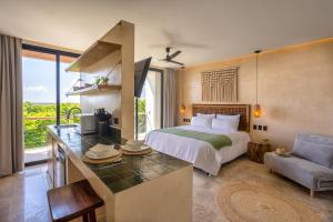 a bedroom with a bed and a desk with a couch at Lalola DownTown Boutique Apartments in Puerto Morelos
