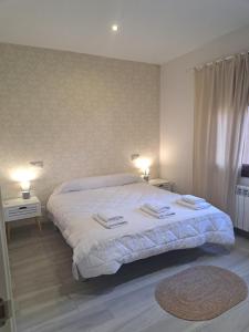 a bedroom with a large bed with towels on it at Casa Gabritana in Sotillo de las Palomas