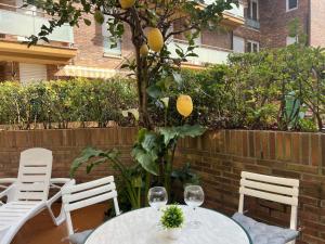 two tables and chairs with wine glasses and a lemon tree at Circobueno de Isla - 5609 in Arnuero +13 photos