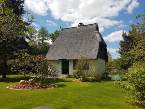 a small white house with a thatched roof at Spreewaldferienhaus Kupa in Burg