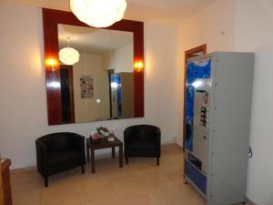 Habitación con 2 sillas, mesa y espejo. en Hostal Alistana, en Madrid