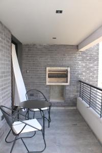 a balcony with a table and chairs and a brick wall at Faz Flat in Córdoba