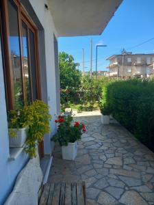 a patio with potted plants on the side of a building at Dario's Apartaments 2 in Orikum