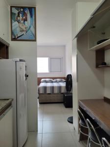 eine Küche mit einem Kühlschrank und ein Schlafzimmer mit einem Bett in der Unterkunft Espaço São Rafael Arcanjo in Cachoeira Paulista + 10 Fotos