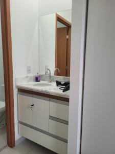 ein Badezimmer mit Waschbecken und Spiegel in der Unterkunft Espaço São Rafael Arcanjo in Cachoeira Paulista