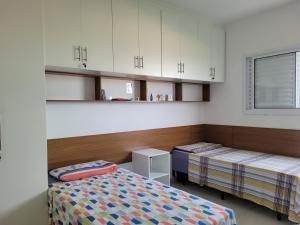 2 Betten in einem Zimmer mit weißen Schränken in der Unterkunft Espaço São Rafael Arcanjo in Cachoeira Paulista