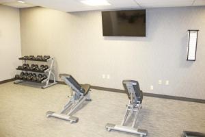 a gym with two rows of exercise equipment and a wall with a television at Courtyard Culver City Los Angeles in Los Angeles