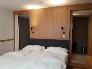 a bedroom with a large bed with two white pillows at East West Hotel Basel in Basel