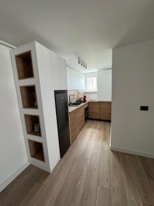Una cocina con gabinetes blancos y un refrigerador negro. en Central Chic Apartment, en Galaţi