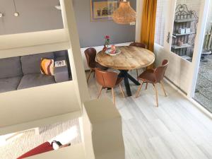 a dining room and living room with a table and chairs at Huize Beemsterlaan in Bergen