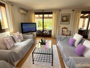 a living room with two couches and a tv at Villa Maria in Port de Pollensa