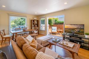 a living room with a couch and a tv at Casa Azul by Paradise Retreats in Santa Barbara