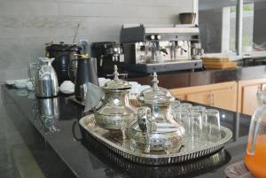a kitchen counter with glass jars and glasses on a tray at Hôtel Asswar Al Madina in Fez