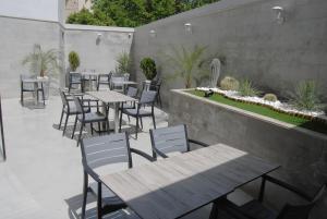 an outdoor patio with tables and chairs and a garden at Asswar Al Madina in Fès