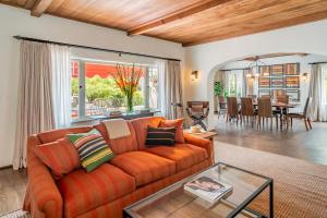 圣巴巴拉Casa del Sol by Paradise Retreats的客厅里有一张橙色的沙发和一张桌子。