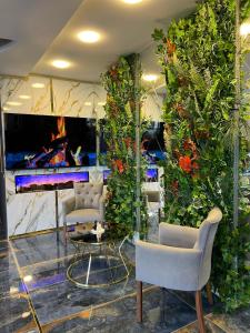 a room with plants and chairs and a fireplace at City Night Hotels Ümraniye in Umraniye
