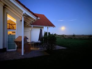a house with the sun setting in the background at Villa Ostseebrise in Trent