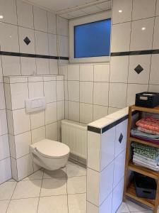 a white bathroom with a toilet and a window at Ferienwohnung Schwung in Idar-Oberstein