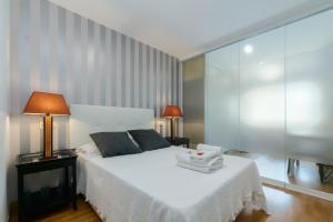 a bedroom with a white bed and a glass wall at Playa Sanxenxo in Sanxenxo +194 photos
