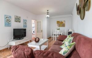 a living room with a couch and a tv at Stunning Home In Chiclana De La Fronter in Chiclana de la Frontera