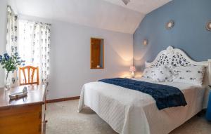 a bedroom with a white bed and a blue wall at Stunning Home In Chiclana De La Fronter in Chiclana de la Frontera