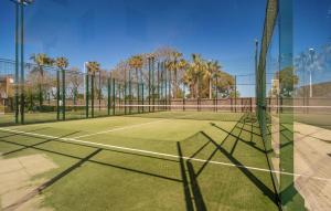 a tennis court with a net on top of it at Beautiful Apartment In Chipiona in Chipiona +16 photos