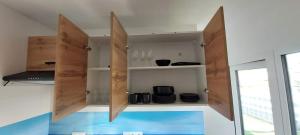 a kitchen with wooden cabinets with plates and utensils at Herada Domek 1 in Jastarnia