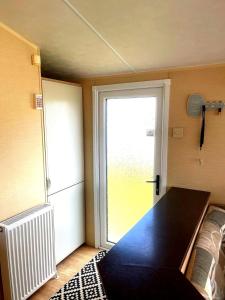 Zimmer mit einem Tisch und einer Glasschiebetür in der Unterkunft Spacious 8-Berth Caravan at Unity Beach Resort in Brean