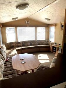 ein Wohnzimmer mit Sofa und Tisch in der Unterkunft Spacious 8-Berth Caravan at Unity Beach Resort in Brean + 22 Fotos