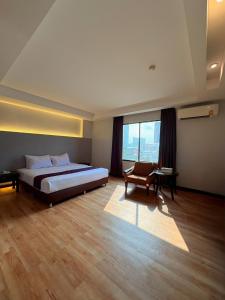 a bedroom with a bed and a chair and a window at Atrium Boutique Hotel in Bangkok +14 photos